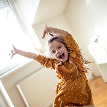 Let's fun. Little girl dancing at home.